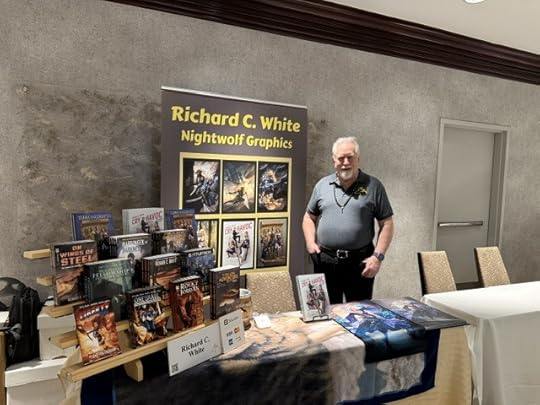 Picture of the author standing behind his display table at PenguiCon 2026 before the show officially started.