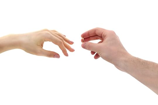 A close-up of two hands reaching towards each other, one hand holding a gold ring.