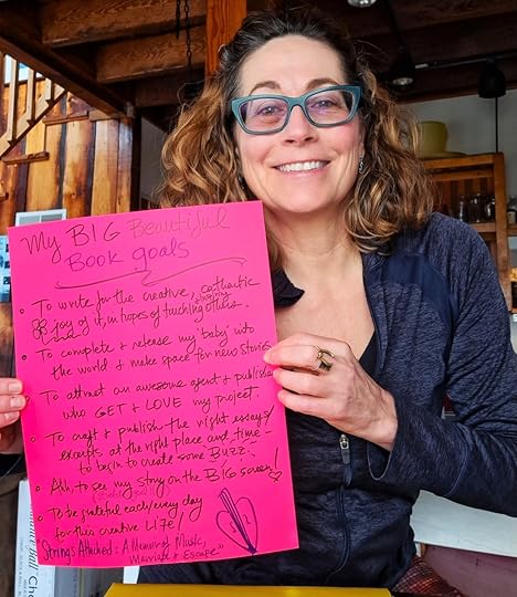 Anne Marina Pellicciotto holding a neon pink piece of paper on which is a written a list of goals and titled 