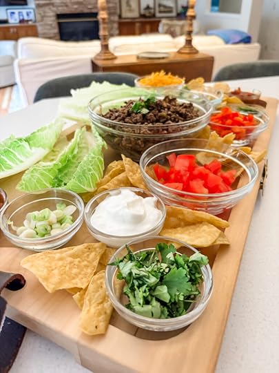 Low-carb taco board with romaine lettuce cups, seasoned beef, and colorful toppings arranged on a large wooden serving board
