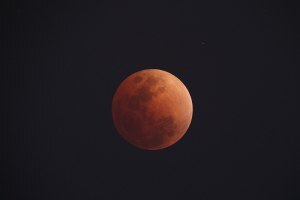 Image of the Blood moon, red, against a dark background 