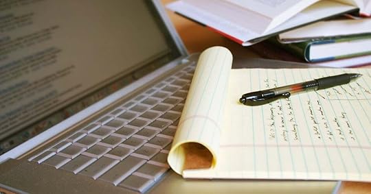 A desk with a laptop and notebook, on which a seller is taking notes.