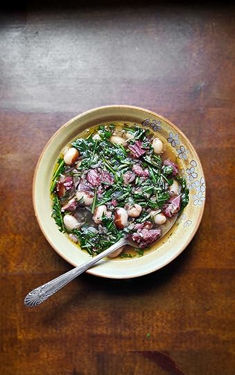 A bowl of dandelion soup on a wooden countertop.