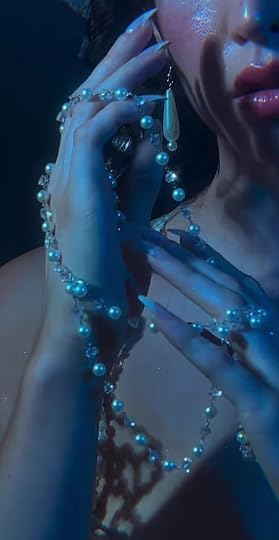 This may contain: a woman with blue makeup holding a cell phone to her ear and wearing pearls around her neck