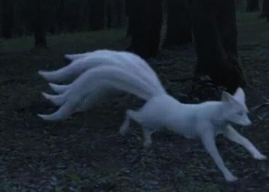 This may contain: a white fox is running through the woods with its tail spread out and it's eyes open