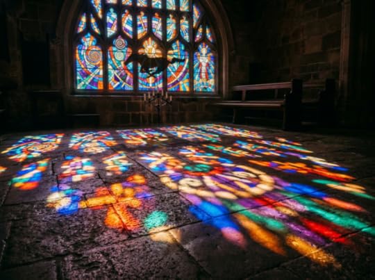 Colorful stained glass light patterns on stone floor of church interior