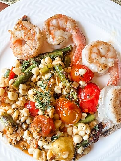 Springtime succotash with lemon and dill served alongside grilled shrimp on a white dinner plate