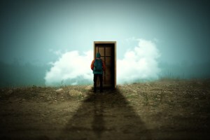 Boy stands on hillside in front of a door that leads to...?