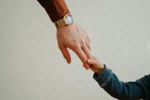 Man holding little boys hand.