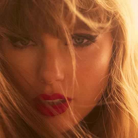 Close up glamour photo of a young woman in golden hour lighting, strands of hair blowing across her face, looking intently at the camera.