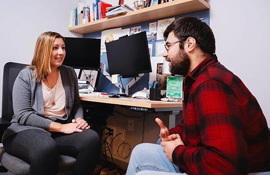 A man and a woman sitting in an office, engaged in conversation.