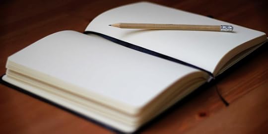 open journal and pencil on wood table