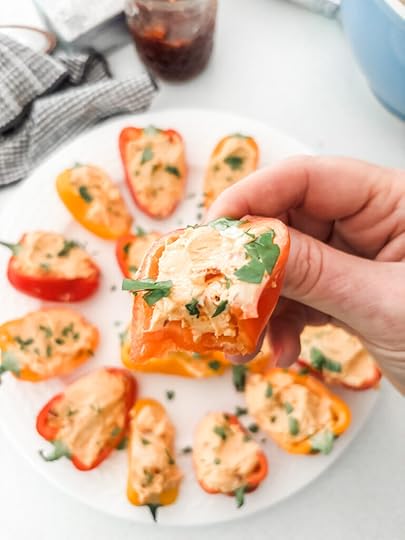 Close-up of a single mini bell pepper stuffed with fluffy cream cheese and hot pepper jelly filling, garnished with chopped parsley