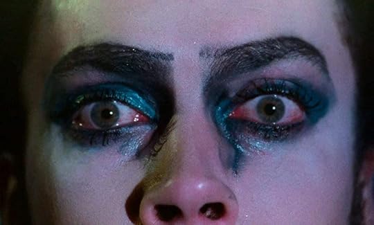 A close-up on the face of Dr. Frank N' Furter, blue eyeshadow smeared with water and tears, in 