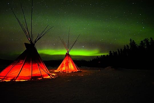 An image of the Yukon northern lights in winter with two tipis in the foreground.