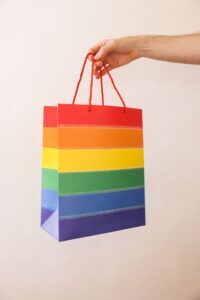 Hand offering a rainbow giftbag