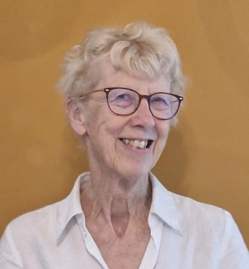 Image shows head and shoulders portrait of Suzanne McConaghy also known as M. G. de Grey, smiling and wearing a white shirt 