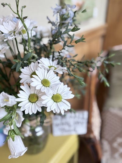 image of daisies and delphiniums in a glass vase