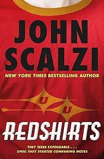 Close up of a red t-shirt with a gold collar. There is a futuristic logo in faded yellow on the chest. Book cover copy reads John Scalzi (in black lettering and Redshirts in white lettering.