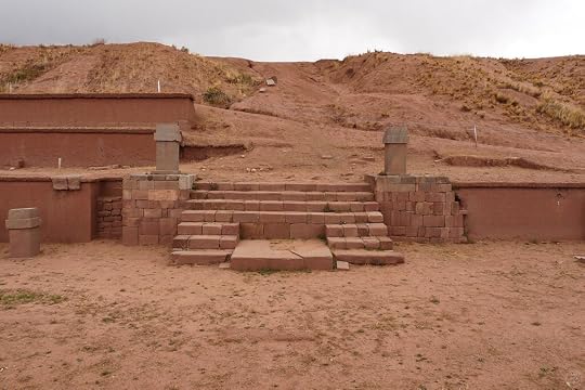 Stone steps leading up to a platform surrounded by earthen walls on a hillside.
