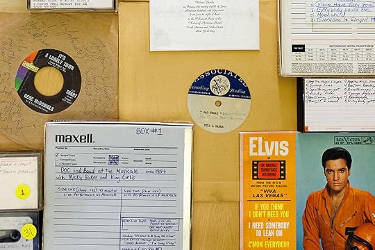 A color photo of several 45 records, tapes and an Elvis Presley record sleeve arranged on a table.
