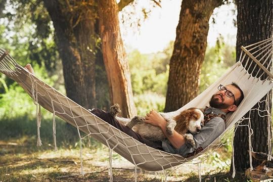 Man sleeping with his dog in a hammock.