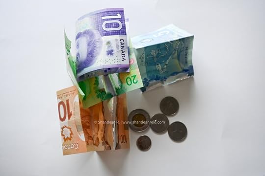 Canadian cash on a surface on the article 5 Financial Tips for Newcomers to Canada written by Shandean Reid on www.shandeanreid.com