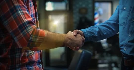 two casually dressed men meet and shake hands