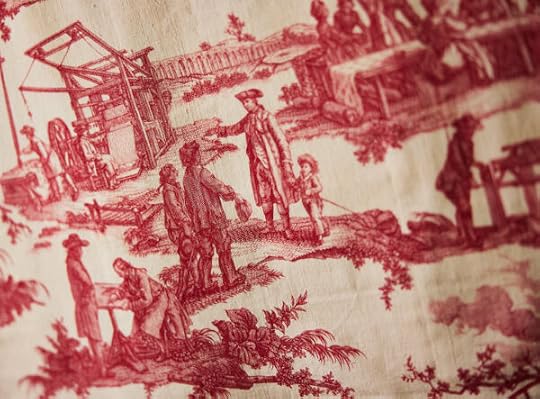 photograph of some fabric showing people working with old time machines outdoors.