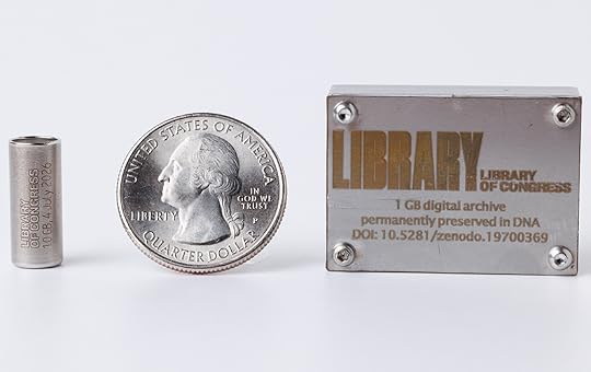 A small metal cylinder, a U.S. quarter and a small rectangular metal box are lined up in a row to show they are all almost the same height.
