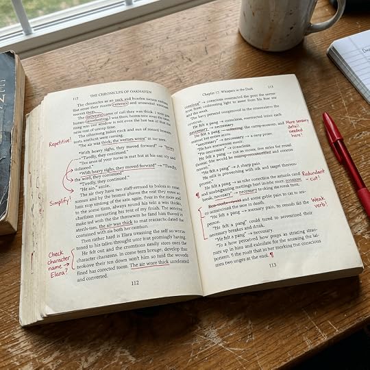 Open book pages with handwritten red ink editing marks and notes