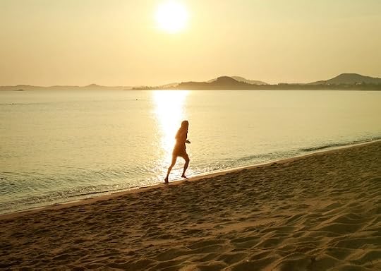 person running on beach in the morning sunlight