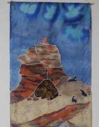 Hand-painted silk banner detail of a mountain peak with fire above two dark cat silhouettes on rocky terrain.
