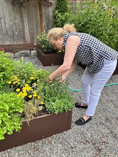 Marie picking parsley from her herb garden