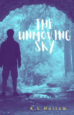 Silhouette of male young adult looking out of a cave into the blue-tinted forest..