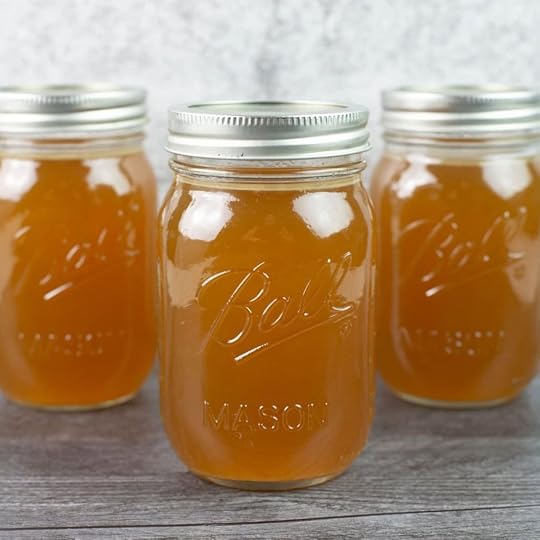 Homemade turkey broth in three large mason jars.