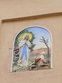L'apparizione della Madonna di Lourdes sotto forma di altorilievo in maiolica, in via Cavour a Manerbio.