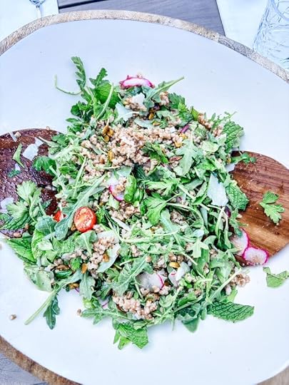 Charlie Bird Salad with farro, shaved parmesan, pistachios, cherry tomatoes, and thinly sliced radishes over arugula and herbs