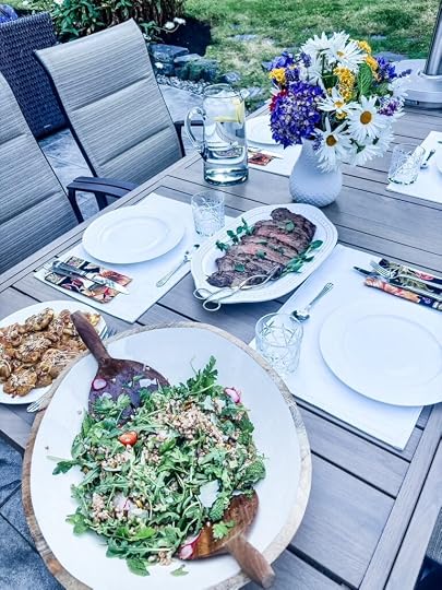 The salad served at a summer al fresco table set with plates and servings of steak
