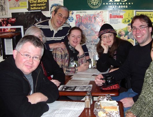 A group of people sitting around a cafe table.