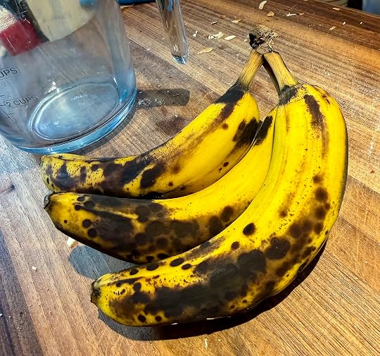 Three yellow bananas with big black splotches from being ripe.