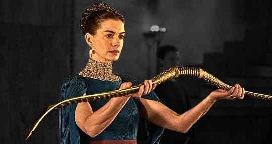 A woman with slicked-back hair, wearing an ornate blue dress and a golden necklace, holds a golden bow with determination.