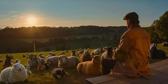 A shepherd sitting on a wooden platform overlooking a pasture filled with sheep and other animals at sunrise.