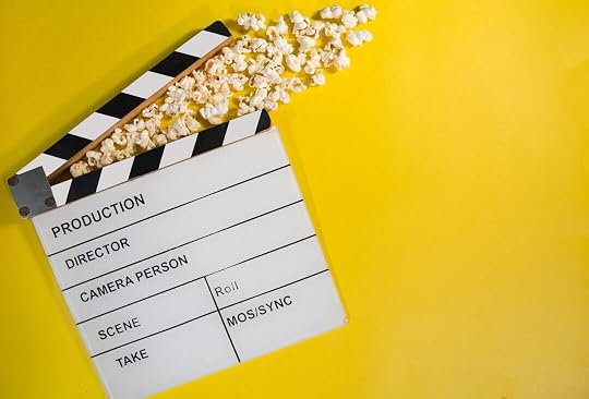 movie clapperboard with popcorn on yellow background