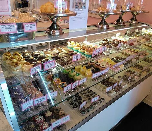 This may contain: a display case filled with lots of different types of pastries
