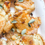 Close-up of a crispy smashed potato showing golden crunchy ridges and a creamy tender center