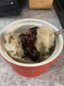 scoops of banana nice cream topped with hot fudge in a small red dish