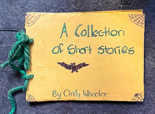 A handmade book covered in yellow paper and bound by green yarn, titled 
