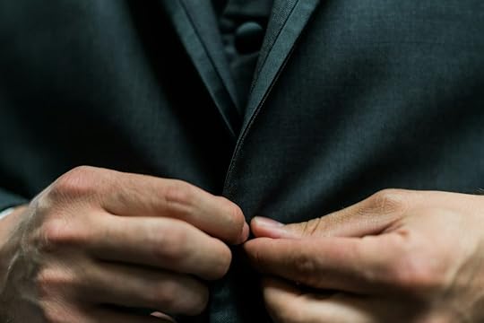 person holding black suit jacket button