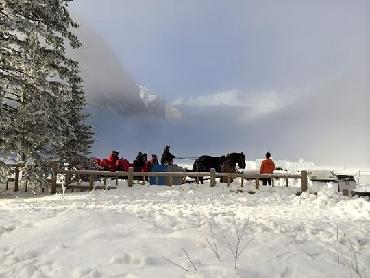 a horse and sleigh with mountains behind